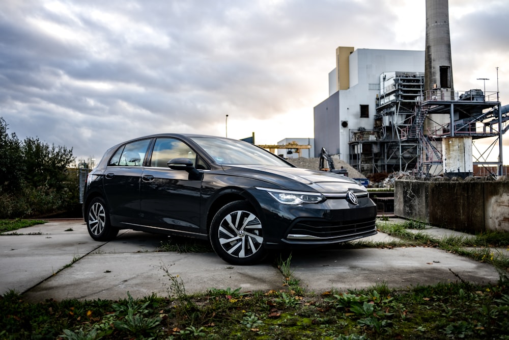 a black car parked in front of a factory