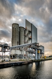 a large industrial building next to a body of water