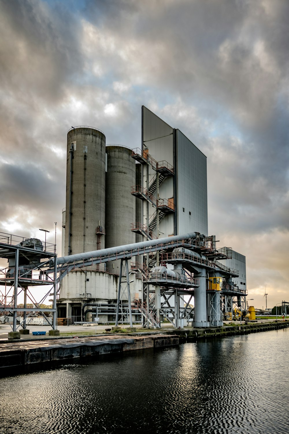 a large industrial building next to a body of water