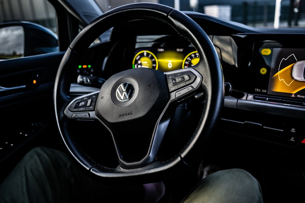 a car dashboard with a steering wheel and dashboard lights