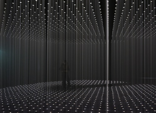 Installation shot of video and sound art blending light and shadow.