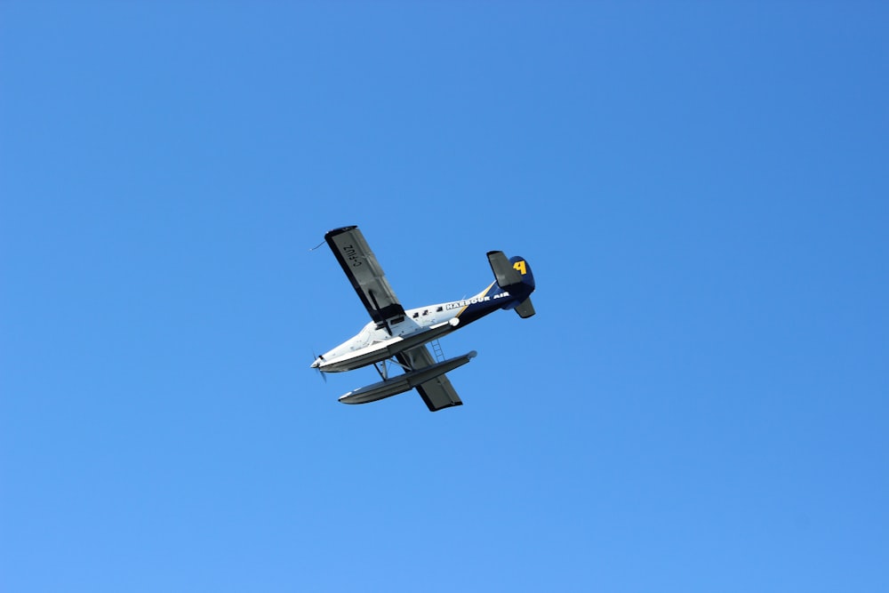 a small airplane flying through a blue sky