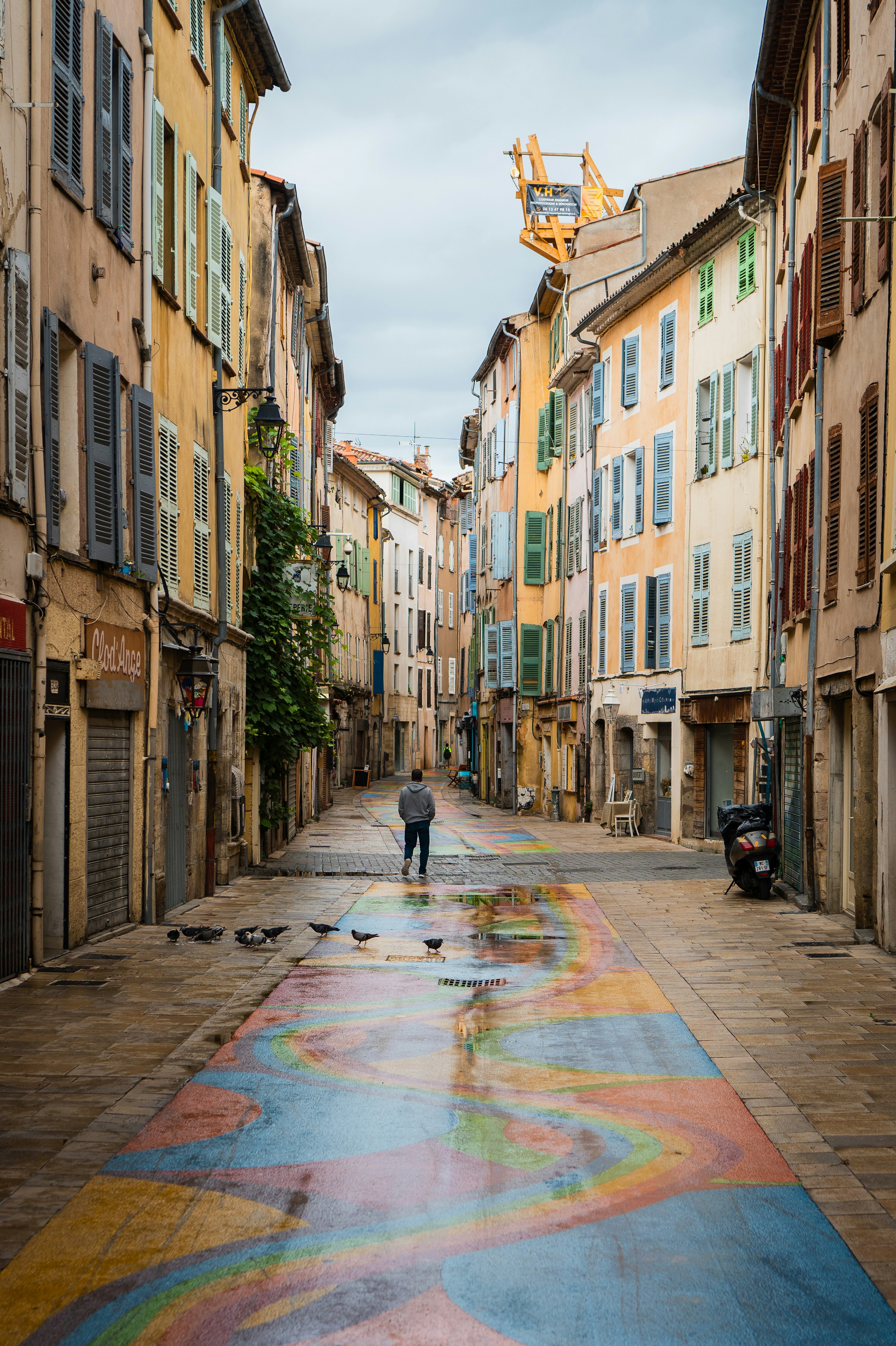 un uomo che cammina lungo una strada accanto a edifici alti