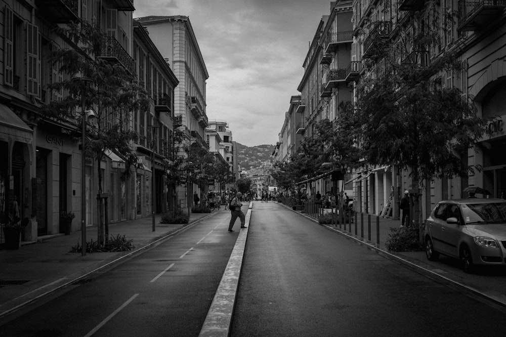 a black and white photo of a person walking down a street