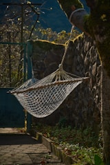 A hammock hanging between two trees in a quiet garden.