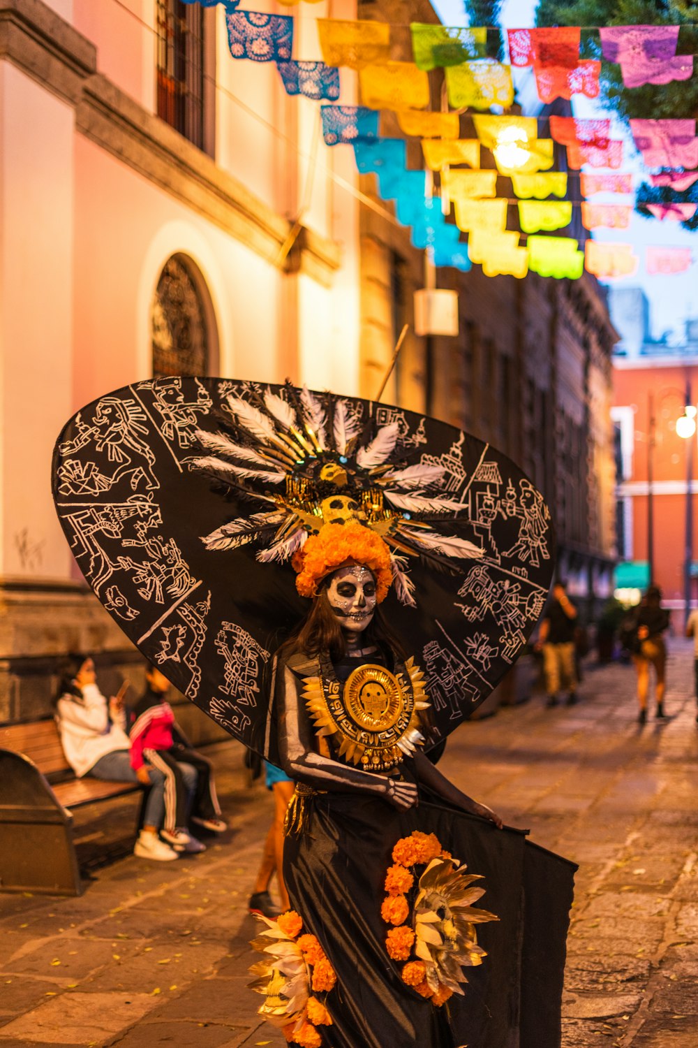 a woman in a costume and headdress walking down a street