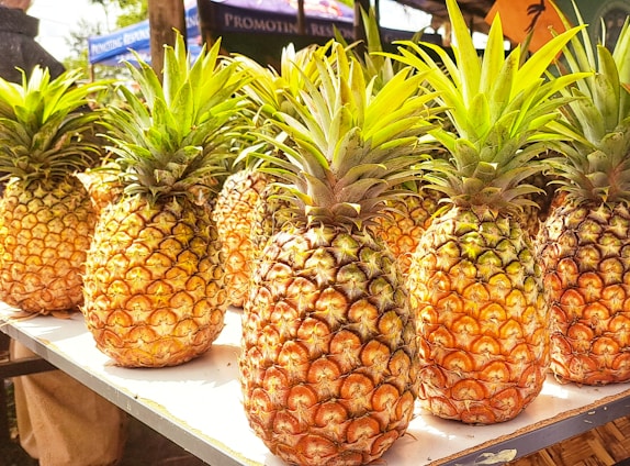 A vibrant display of fresh pineapples in an orange-themed setting.