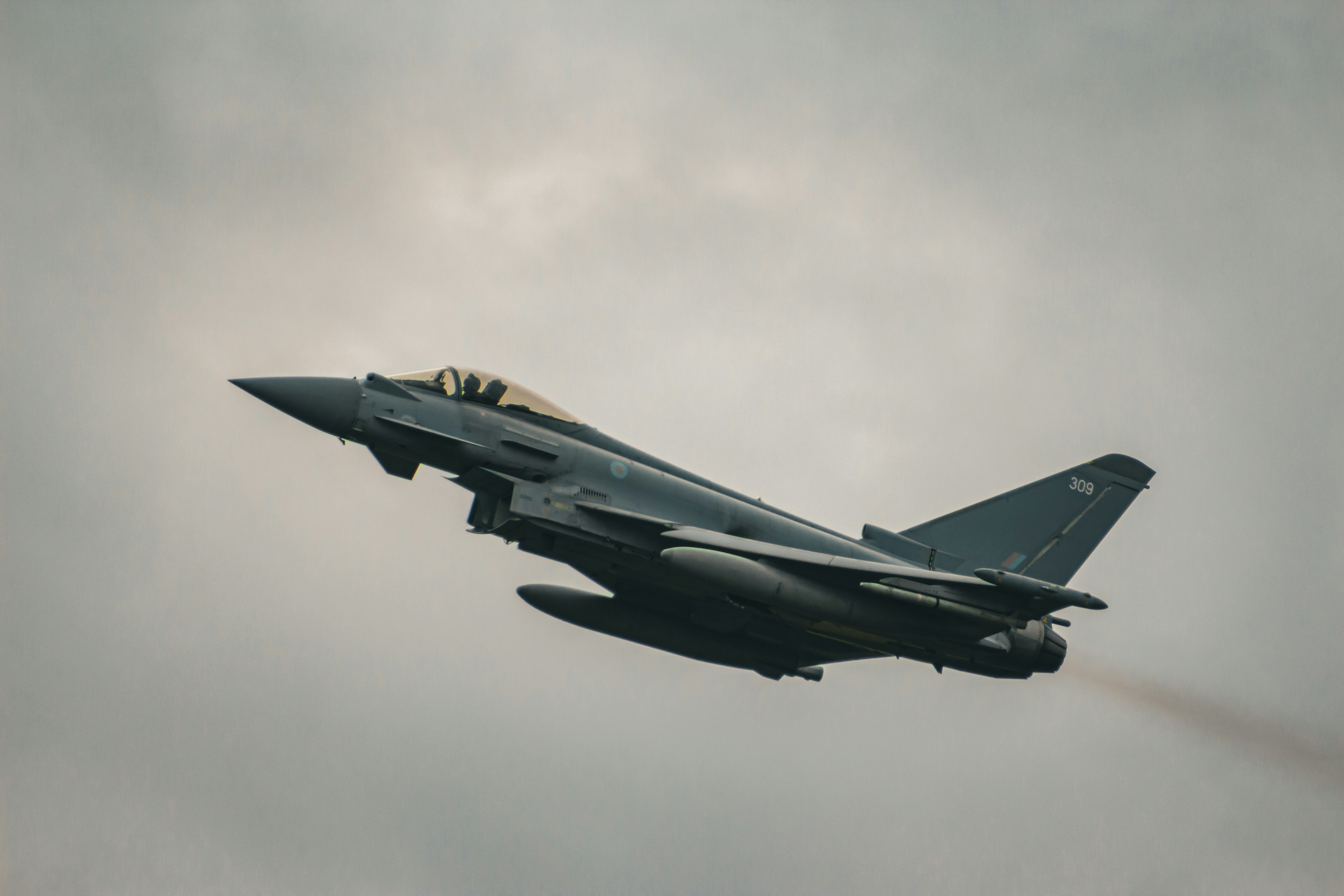 a fighter jet flying through a cloudy sky, RAF Eurofighter Typhoon