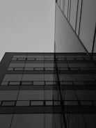 A sleek modern building under construction against a gray sky.