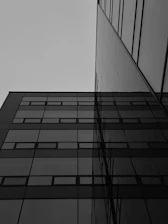 A sleek modern building under construction against a gray sky, reflecting precision and care.