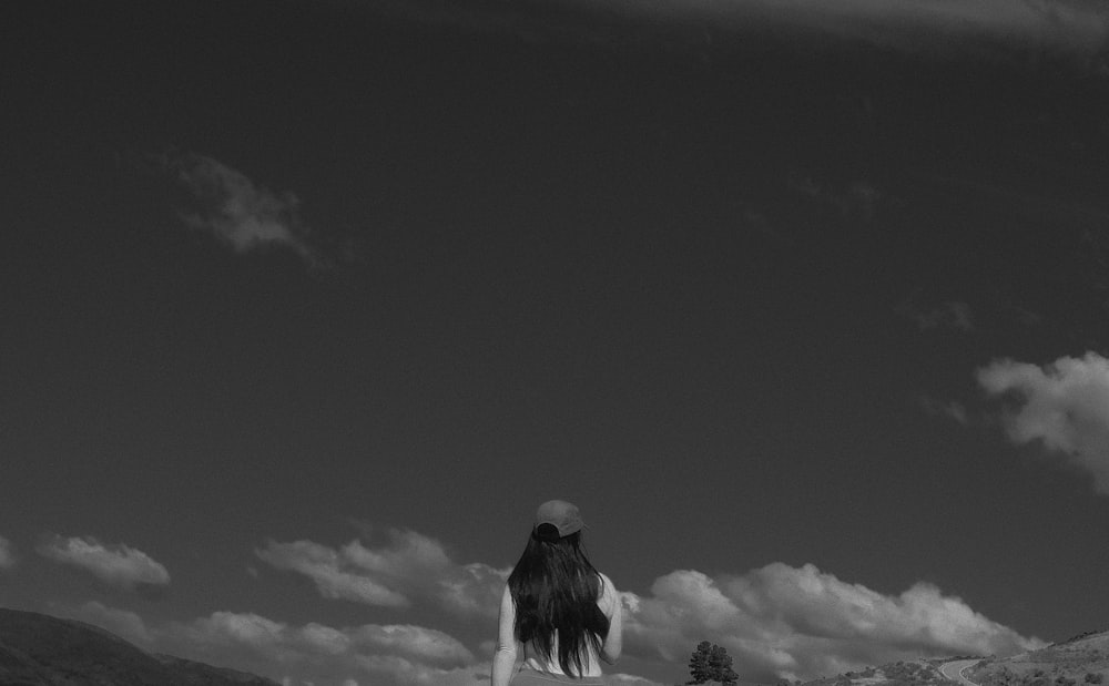 a woman standing in a field with a frisbee in her hand