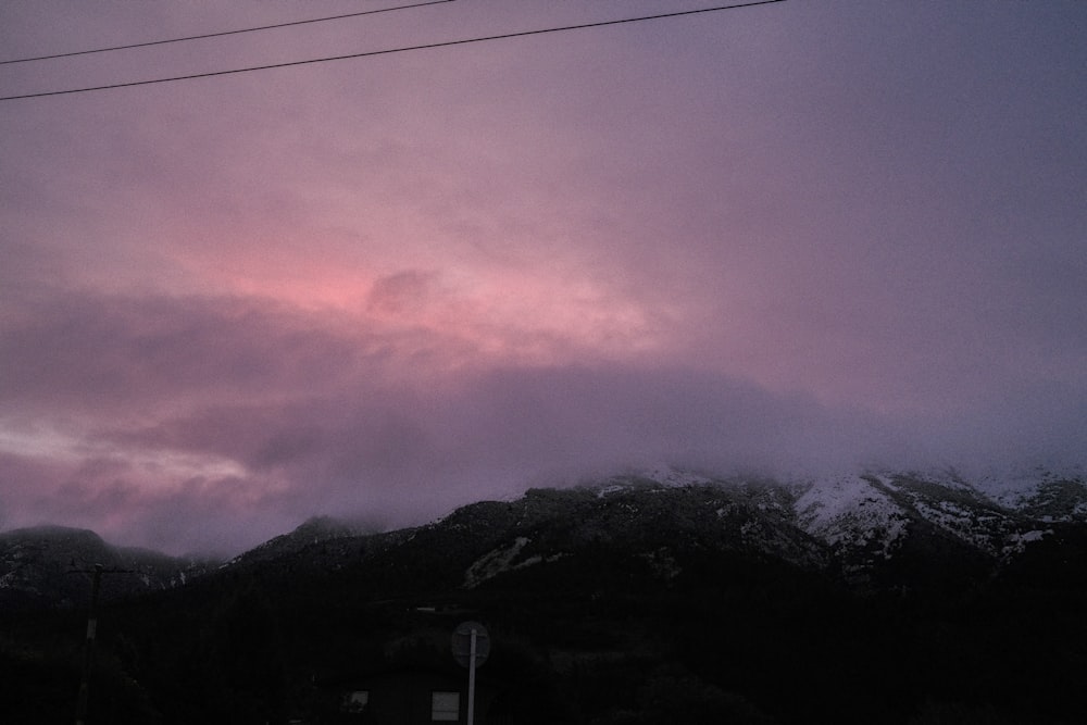 a cloudy sky with mountains in the background