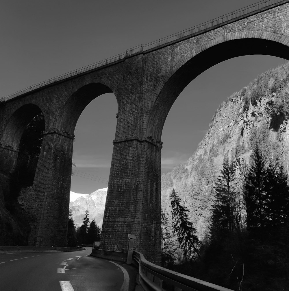 a black and white photo of an old bridge