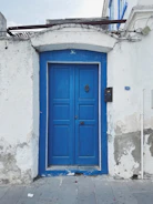 Technician in blue uniform repairing a modern home's front door with visible before-and-after sections.