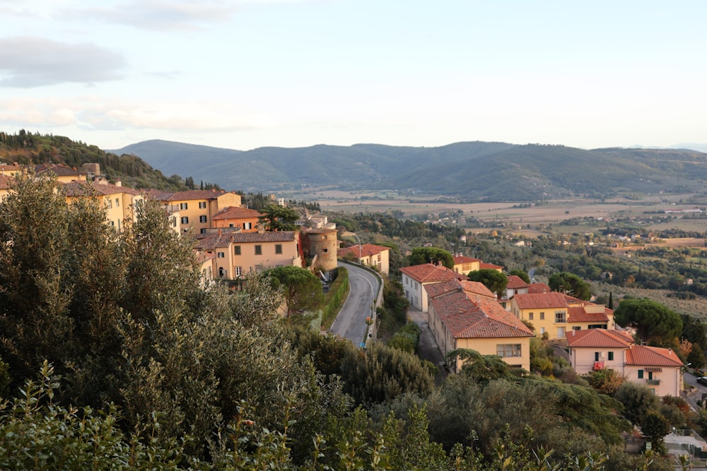 a small village on a hill with a road going through it