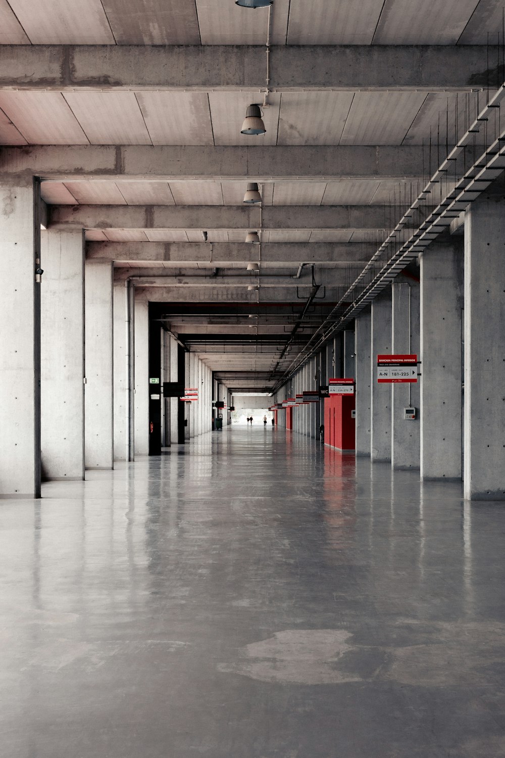 a long hallway with a red fire hydrant in the middle of it