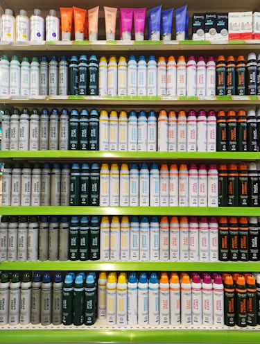 Rows of colorful lubricant containers stacked in a warehouse aisle.