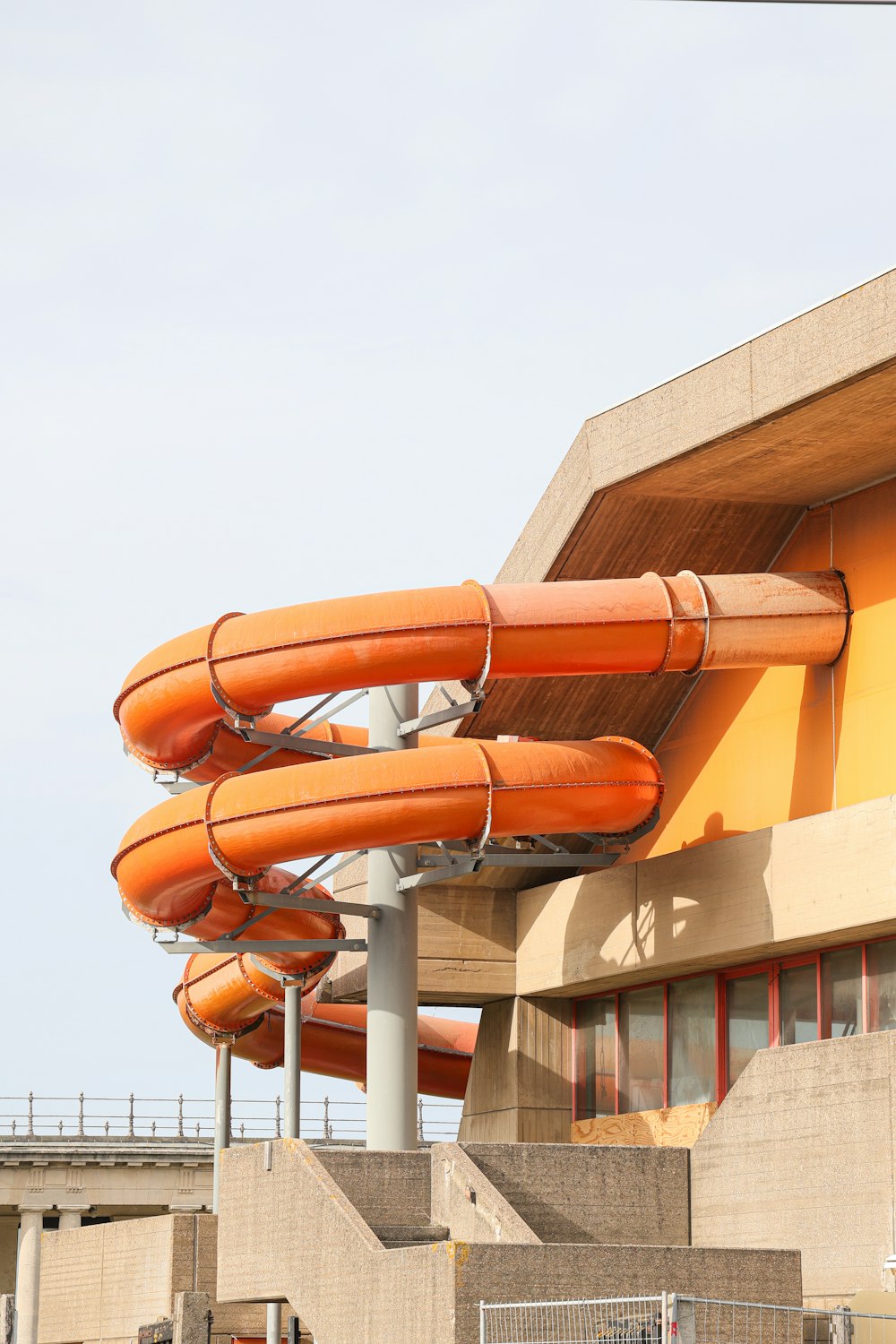 Une rangée de toboggans aquatiques orange devant un bâtiment