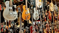 An assortment of guitars displayed on a wall.