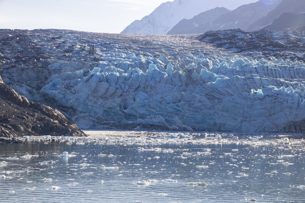 a large glacier with a mountain in the background