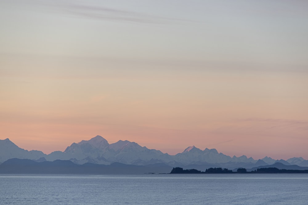 a large body of water with mountains in the background