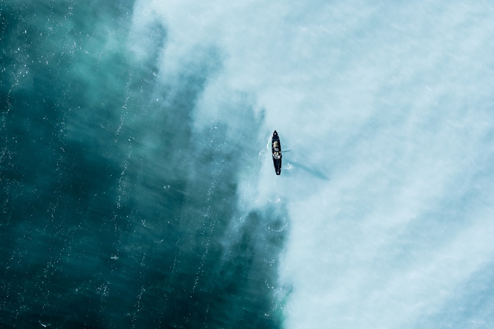 an aerial view of a boat in the ocean