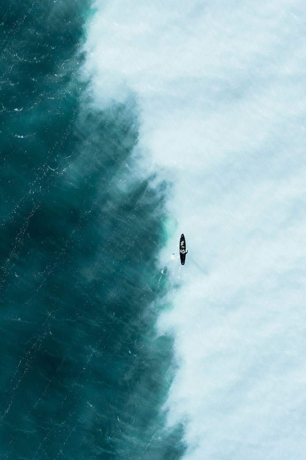 an aerial view of a boat in the ocean