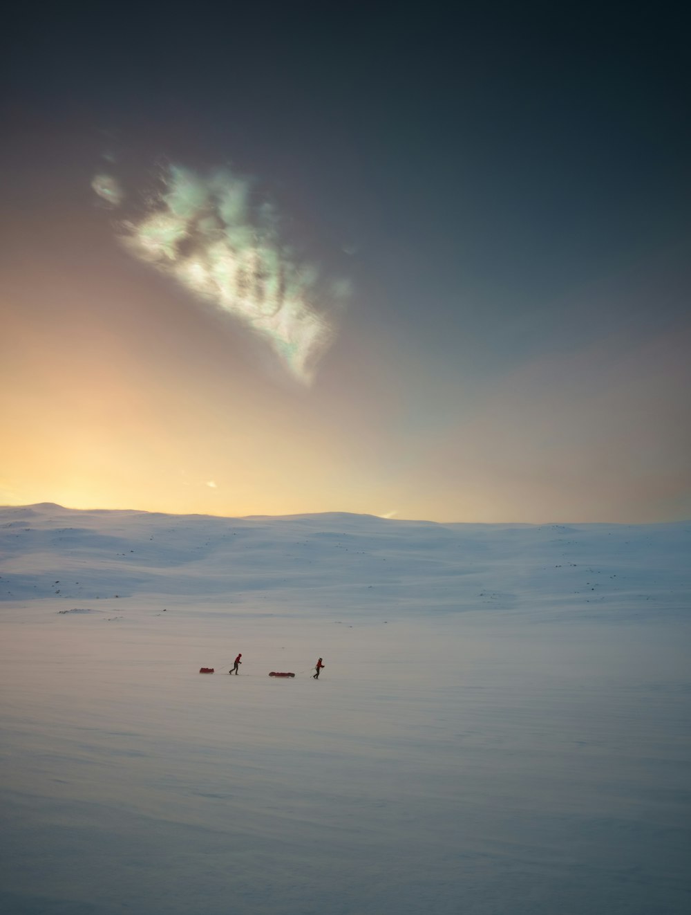 a group of people walking across a snow covered field