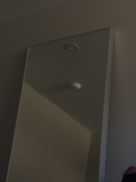 Close-up of a sleek smoke detector installed on a smooth ceiling with soft natural light