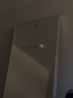 Close-up of a radon detector placed in a living room corner during an inspection.