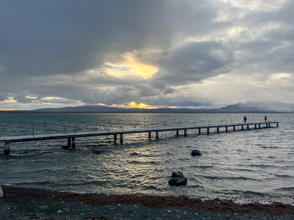 a long pier stretches out into the ocean