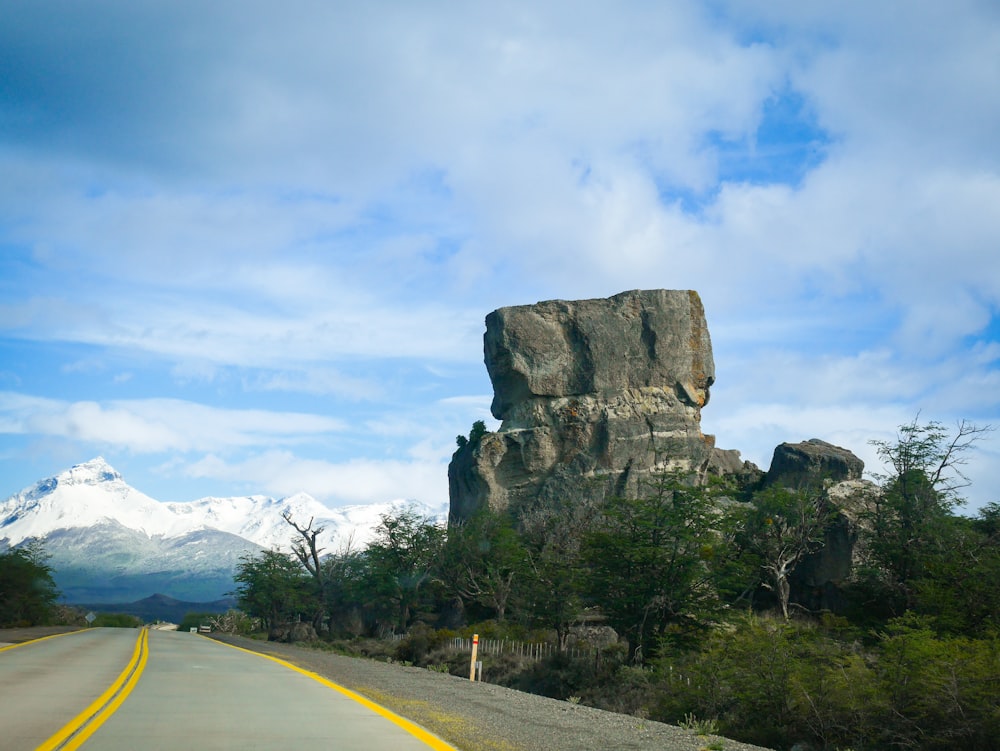 a large rock sitting on the side of a road