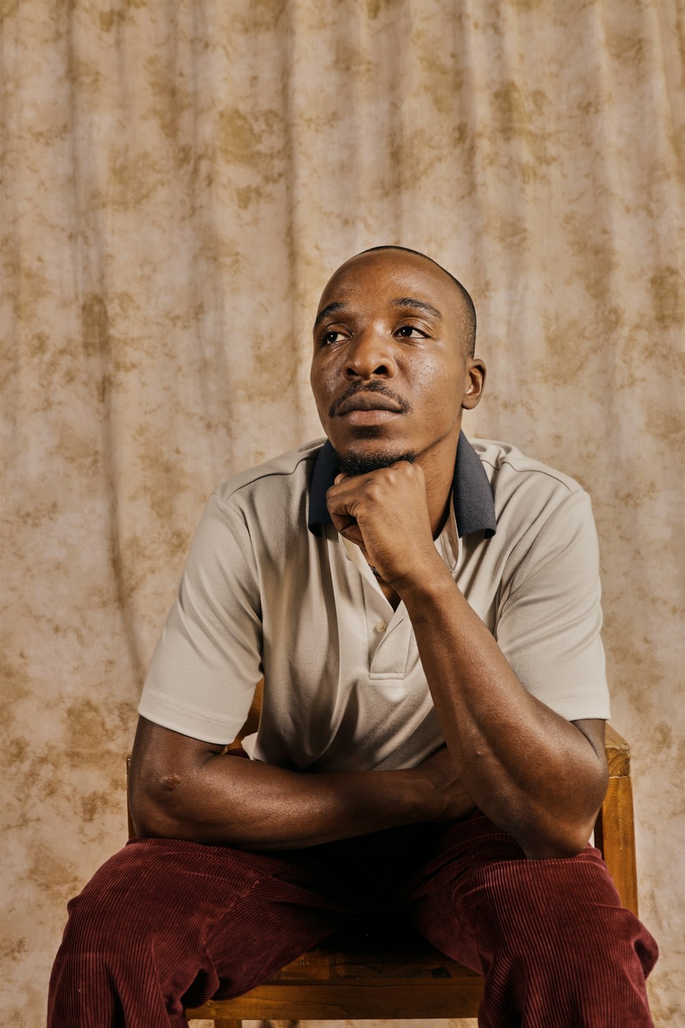 a man sitting on top of a wooden chair