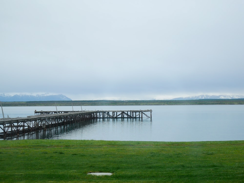 a large body of water sitting next to a wooden pier
