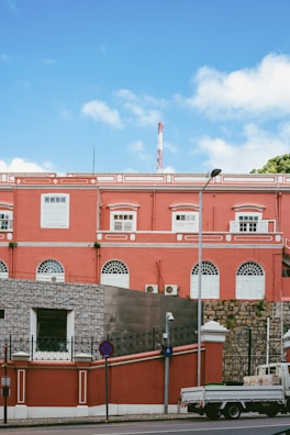 Freshly painted bright red commercial building exterior under clear sky.