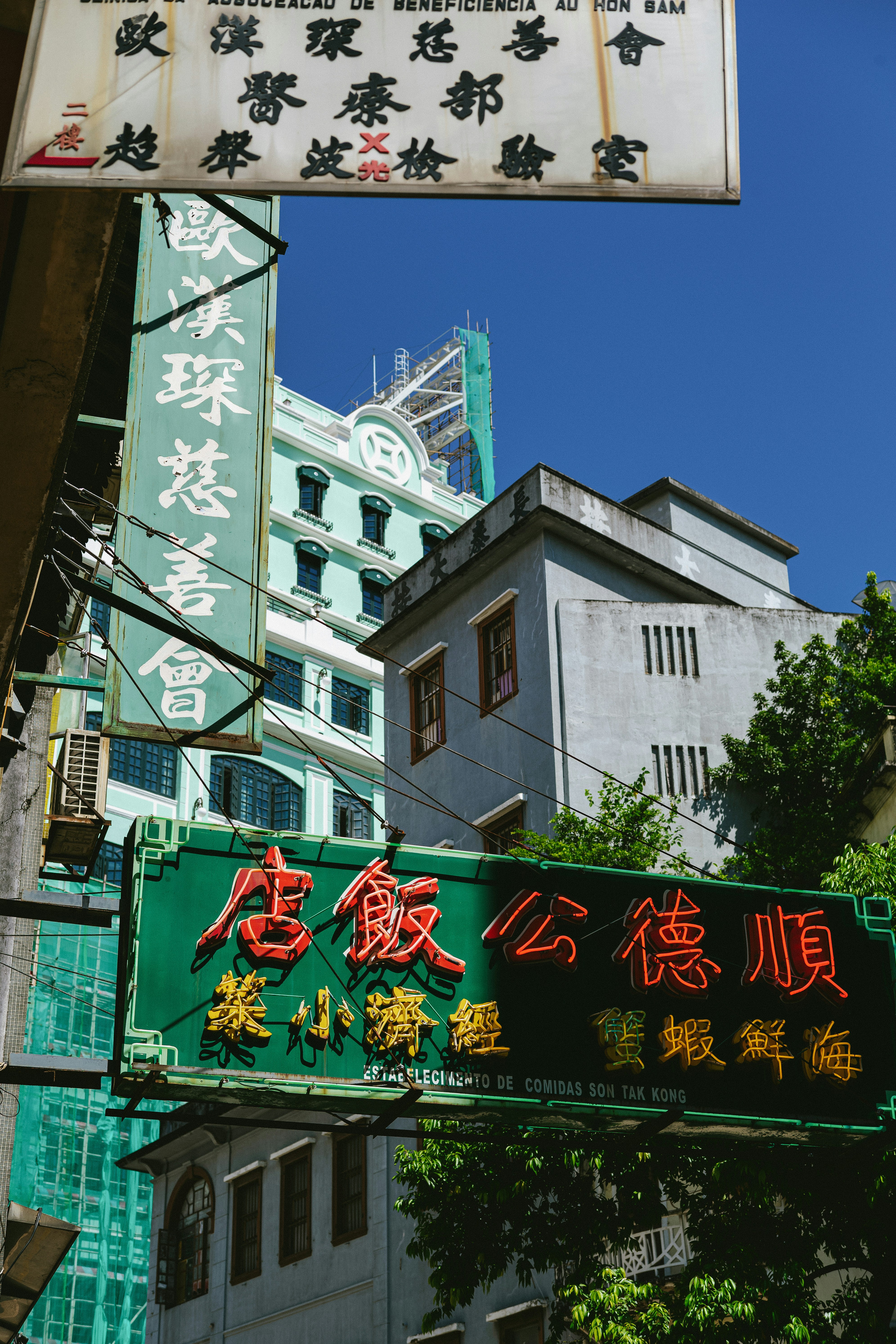 a street sign in a foreign language with buildings in the background