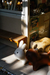A cozy virtual park scene with animated 2D pets like a dog, cat, and rabbit playing near a flower-filled bench.