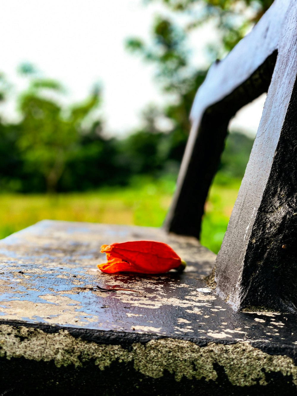 a red piece of cloth sitting on top of a wooden bench