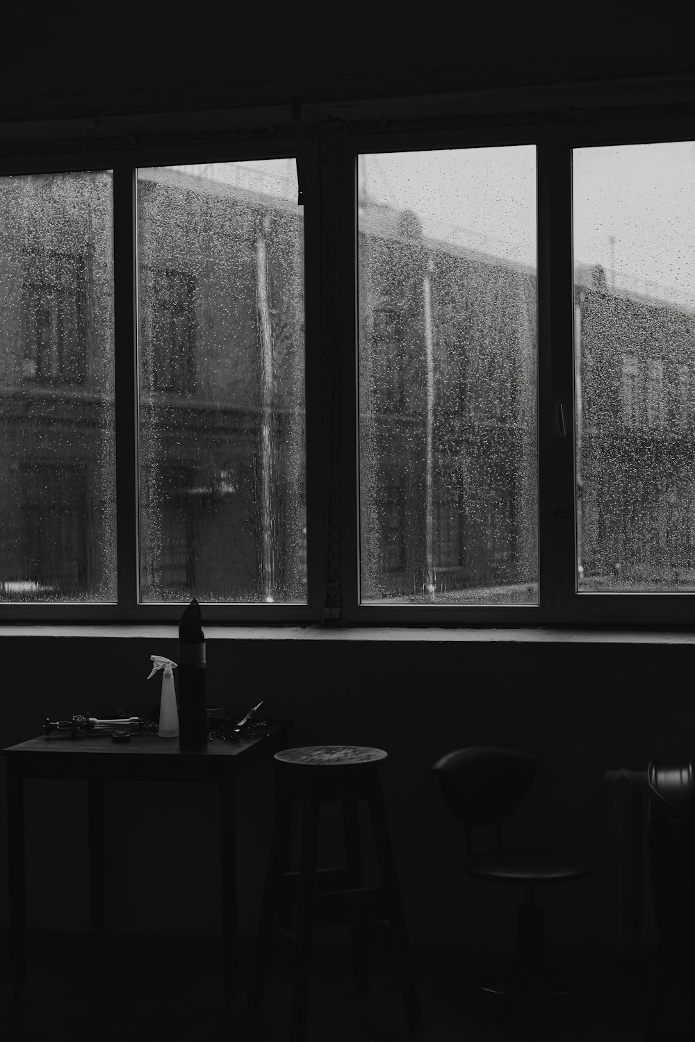 a black and white photo of a window with rain coming in
