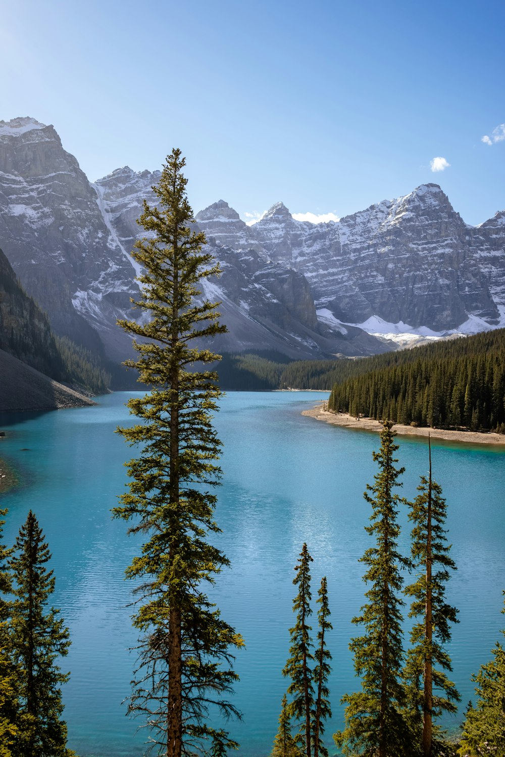 Um lago azul cercado por montanhas e árvores