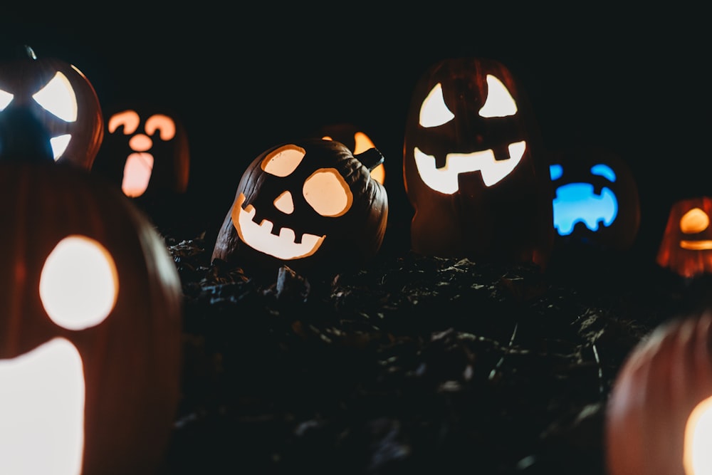 a group of carved pumpkins with glowing faces