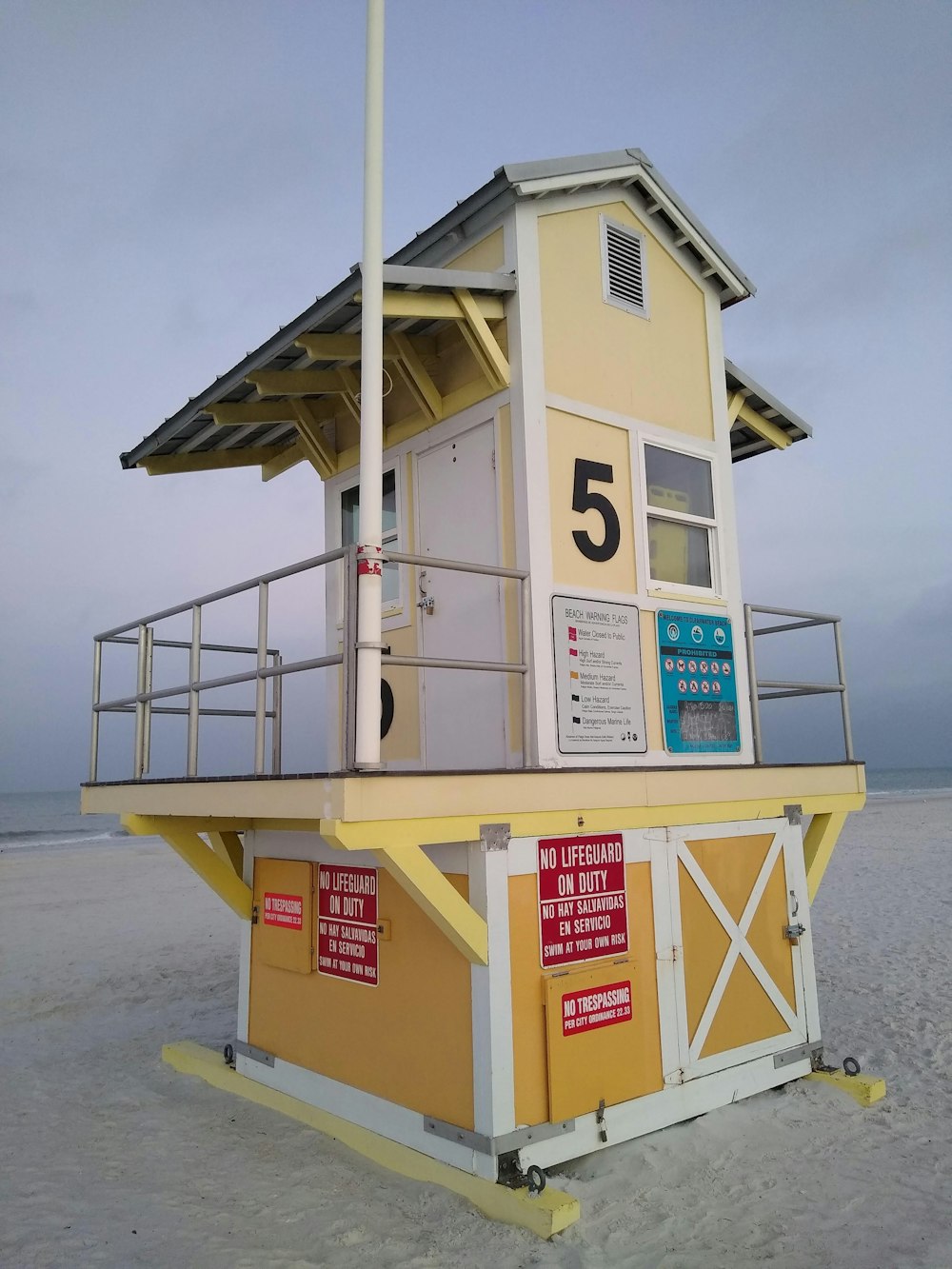 a lifeguard station on the beach with a flag on top