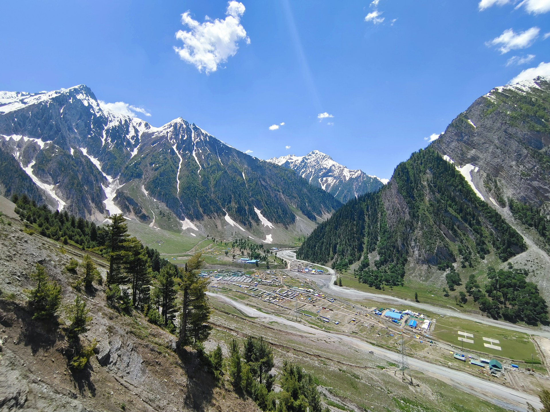 a scenic view of a mountain range with a camp site in the foreground