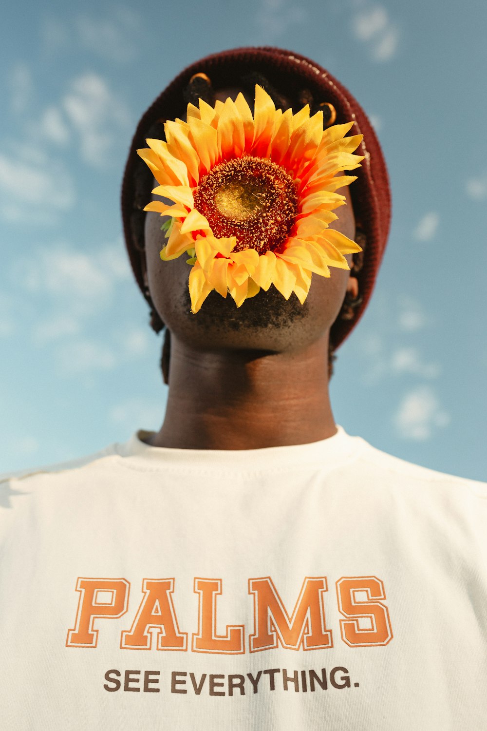 a man with a sunflower on his head