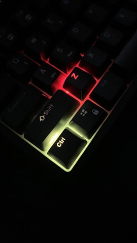 Close-up of a sleek keyboard with the letters Z, A, W, L illuminated in bright neon blue.