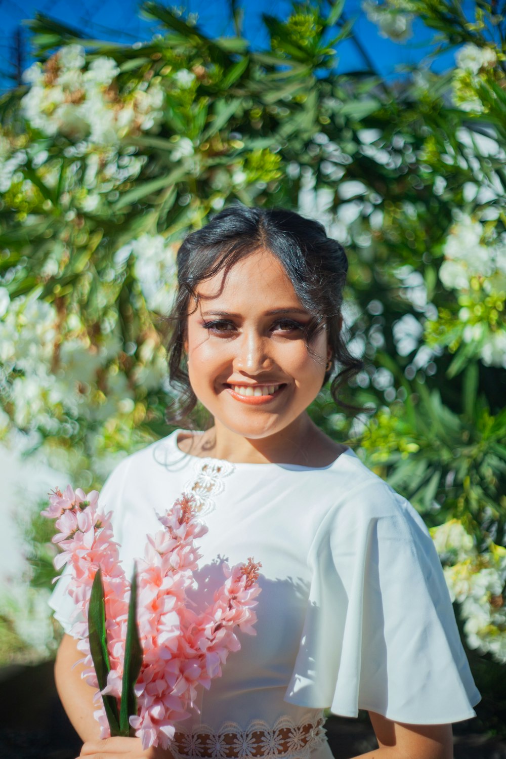 a woman in a white dress holding a plant