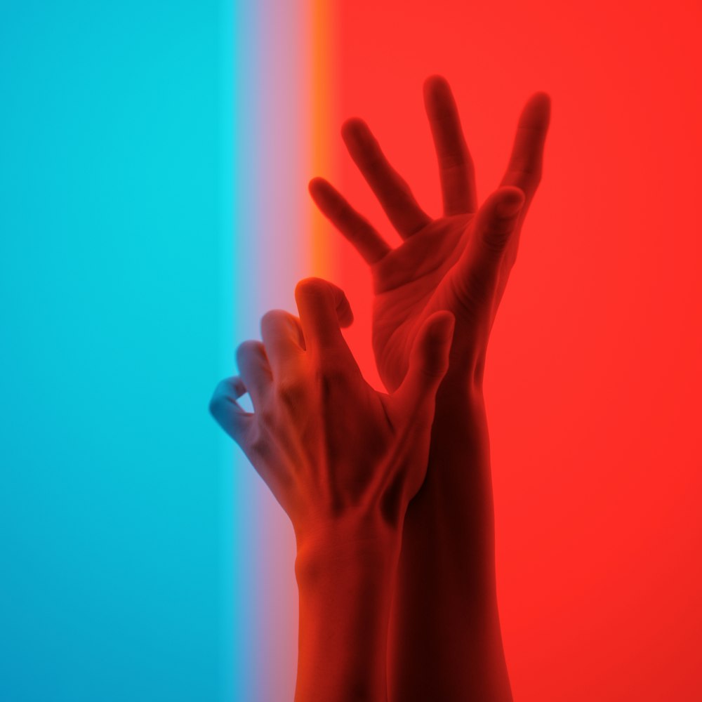 a person's hand reaching up to a multicolored wall