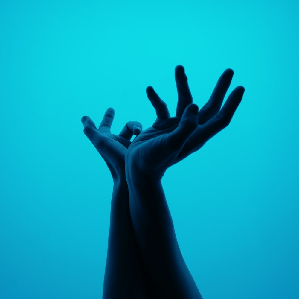 a person's hands reaching up into the air