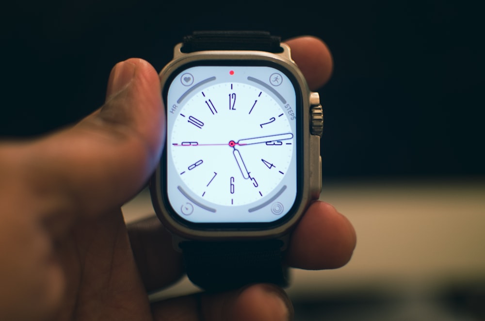 a person holding a smart watch in their hand
