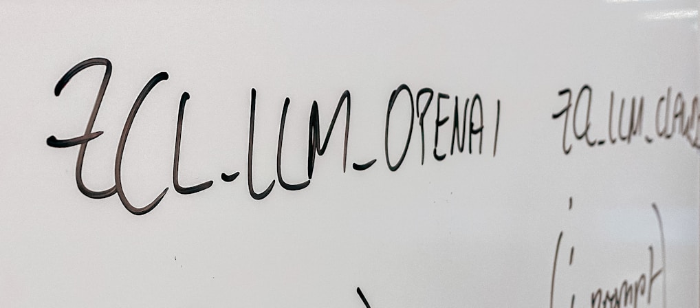 Handwritten text in black marker on a whiteboard with various words and symbols visible.